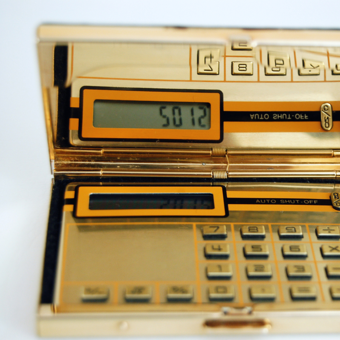 Gold folding pocket calculator with a mirrored lid